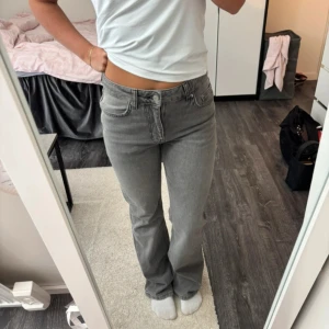 Grå bootcut jeans i stretch - Snygga grå jeans med bootcut passform och klassisk femficksdesign. Jeansen har låg midja och är tillverkade i stretchigt denim för en bekväm känsla. Perfekta för dig som gillar en avslappnad men ändå trendig look.