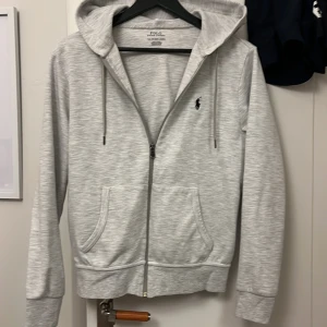 Polo Ralph lauren Zip Hoodie  - Säljer en grå Ralph lauren zip hoodie i nytt skick storlek xs passar perfekt för dig som är 165-171 typ