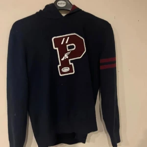 Ralph Lauren hoodie - Säljer en väldigt snygg stickad Ralph Lauren hoodie med ett stort P på. Knappt använd och inga skador samt defekter. Nypris ca 2000kr. Säljer för att den är för liten. Hojta till om de är några frågor!