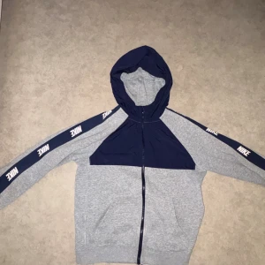 Nike hoodie i grått och marinblått - Nike hoodie med dragkedja i grått och blått.