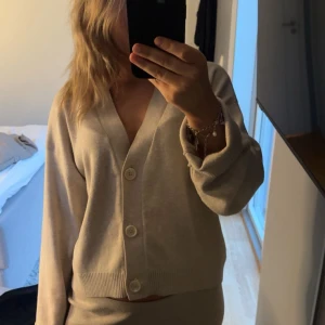 Beige kofta H&M - Säljer en beige kofta med v-ringning och tre stora knappar framtill. Så mysig och skön