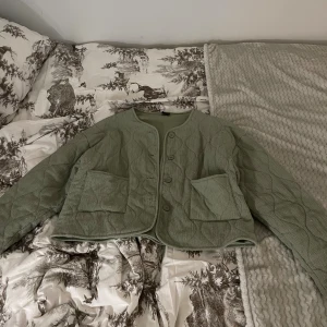 Quiltad grön jacka från Gina Tricot - Snygg quiltad jacka i ljusgrönt från Gina Tricot. Jackan stora fickor framtill och stängs med knappar. Jätteskön och super fin nu till höst eller vår. Storlek L men kan va en snygg oversized jacka! Använd fåtal gånger
