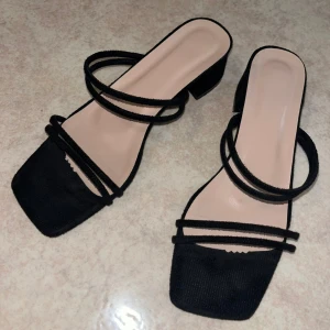 Klackskor - Snygga svarta klackskor med låg klack och fyrkantig tå. De har tunna remmar över foten och runt vristen för en trendig look. Perfekta till alla outfits och passar dig som gillar minimalistisk stil. Enbart använda 1 kväll. Klacken är ca 4cm