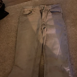 Beige Perfect Jeans från Gina Tricot - Snygga beige jeans från Gina Tricot, modell Perfect Jeans. Klassisk femficksdesign, raka ben och normal passform. Jeansen är tillverkade i bomull och har en stilren look som passar till det mesta. Perfekt för dig som gillar en enkel och clean stil.