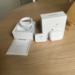 AirPods Pro - Säljer ett par AirPods Pro i mycket fint skick, komplett med originalförpackning, laddningskabel och manual. Hörlurarna och laddningsladd. Perfekt för dig som vill ha aktiv brusreducering och trådlös frihet.