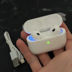 AirPods Pro - trådlösa hörlurar  - Snygga AirPods pro med laddningsetui och laddkabel. Trådlösa hörlurar med aktiv brusreducering och bekväm passform. Produkten ser ut att vara i mycket gott skick, med skyddsplast kvar på etuiet. Perfekt för musik, samtal och träning.
