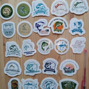 Sportfiskeklubben fiske stickers - Ett set med färgglada fiske-relaterade stickers från Sportfiskeklubben, perfekta för att dekorera utrustning, laptop eller vattenflaska. Motiven inkluderar fiskar, fiskeuttryck och klubbmärken. Stickers är i nyskick utan synligt slitage eller defekter.