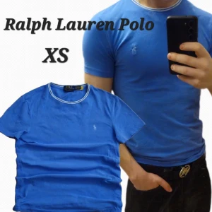 Blå Ralph Lauren Polo t-shirt XS - Snygg blå t-shirt från Ralph Lauren Polo i modellen Custom Slim Fit. T-shirten har korta ärmar, vit rand vid kragen och den klassiska broderade loggan på bröstet. Perfekt för dig som gillar stilrena och sportiga plagg.