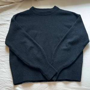 Svart stickad tröja från BikBok - Säljer nu min supermysiga svarta stickade tröja från BikBok i storlek S. Tröjan har rund hals, ribbade muddar vid ärmslut och nederkant samt långärmad passform. Perfekt för dig som gillar enkel och stilren look med lite loose fit 🖤