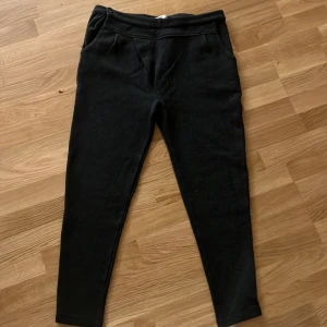 Grå mjukisbyxor med fickor - Grå mjukisbyxor med smal passform och hög midja. Byxorna har snedställda fickor fram och dekorativa ficklock bak. Perfekta för en chill och avslappnad stil. Tillverkade i mjukt bomullsmaterial för extra komfort.