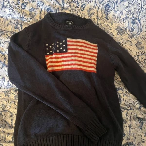 Stickad tröja - Mörkblå stickad tröja med en USA flagga från Crocker. Sparsamt använd. Storlek XS men passar säkert S-M då den är lite större i storleken.  Tvättar allt innan, skriv för mer bilder eller om du har några frågor.💞