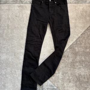 Svarta jeans från Zadig & Voltaire - Snygga svarta jeans från Zadig & Voltaire med klassisk femficksdesign och raka ben. Jeansen har en cool detalj med en liten döskalle på bakfickan och en läderpatch med logga. Tillverkade i Italien i mjukt bomullsmaterial med stretch för extra komfort.