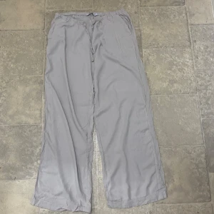 Beige  linnebyxor med snörning - Luftiga begie linnebyxor med avslappnad passform och dragsko i midjan. Perfekta för chill dagar eller när du vill ha något bekvämt men ändå snyggt. Raka ben och enkel stil som funkar till det mesta.