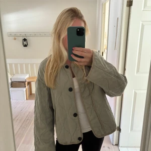 Quiltad jacka från zara - Quiltad jacka från zara med stora svarta knappar framtill. Jackan är i en grå/grön färg. Jättefint skick!