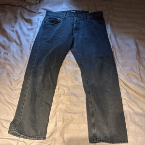 Svarta relaxed jeans Jack & Jones 34/30 - Svarta jeans från Jack & Jones i modellen Relaxed Chris. De har en avslappnad passform med raka ben och klassisk femficksdesign. Jeansen är tillverkade i denim och har en enkel, stilren look som passar till det mesta. Finns en liten märke ibak men absolut inget som märks. 