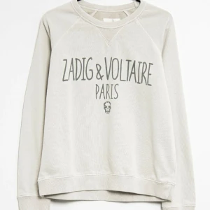 Sweatshirt från Zadig & Voltaire - Grå/beige sweatshirt från Zadig & Voltaire med tryck framtill och rund hals. (Första bilden är tagen från Zalando) Köpt secondhand för 1000kr