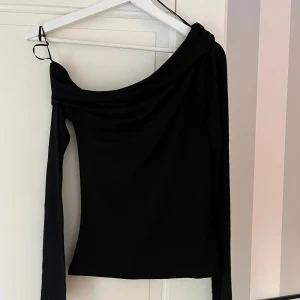 One shoulder tröja - | Off shoulder långärmad tröja från Nelly | Storlek: XS | Färg: Svart | Mjukt och stretchigt material | Använd en gång |