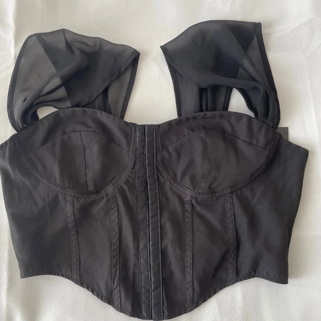 Svart korsettopp med meshärmar