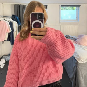 Rosa stickad tröja från Vero Moda - Supermysig rosa stickad tröja från Vero Moda i storlek S. Tröjan har en loose passform, breda ärmar och ribbad struktur. Perfekt för att hålla sig varm och snygg under kyliga dagar. 