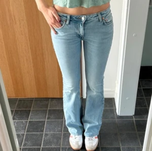 Bootcut jeans 🗽 - Säljer ett par ljusblå jeans från Weekday med bootcut-modell och klassisk femficksdesign. Low waist. L 32 W 26 