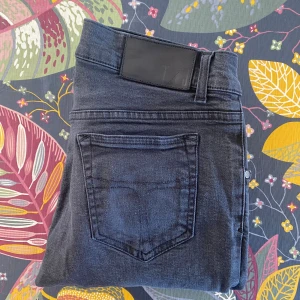Tiger of Sweden jeans  - Snygga mörkgrå skinny jeans med klassisk femficksdesign och svarta detaljer vid midjan. Jeansen har smal passform och är tillverkade i stretchigt denimtyg för en bekväm känsla. Perfekta för dig som gillar en stilren och modern look.