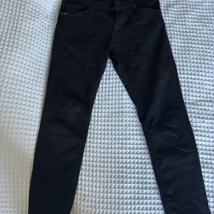 Svarta slim jeans Tiger of Sweden - Ett par fina Tiger of Sweden jeans. Modell: Evolve. Storlek 30/32. Några små vita fläckar på framsidan. Skriv privat för för fler bilder.