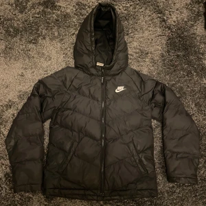Nike puffer jacka - Skulle säga att den passar någon som är mellan 158 och 170cm. Jackan har ett välsytt slitage vid den högra framfickan men utöver det så är den gott omhändetagen och i ett fint skick.