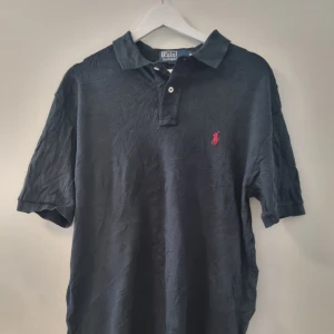 Ralph Lauren pike - Säljer en klassisk pikétröja från Ralph Lauren med korta ärmar. Perfekt för en stilren och avslappnad look.            