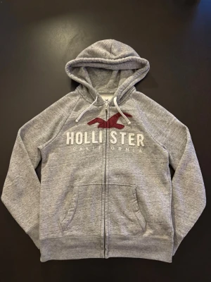 Hollister Hoodie Dragkedja Vintage - Grå Hollister Hoodie Dragkedja Vintage - Pris: 449 kr - Storlek: S - Fin och väl omhändertaget plagg - Först till Kvarn! 