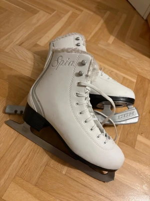 Vita konståkningsskridskor Spin - Säljer ett par  vita konståkningsskridskor från Spin i storlek 40. Fluffigt foder på insidan. Använda några enstaka gånger men väldigt fint skick 🩷skydd till bladen följer med 