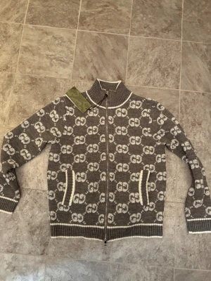 Grå Gucci Kofta - Säljer en helt ny Gucci kofta med ikoniskt GG mönster. Koftan säljs då den var för liten för mig och pris kan diskuteras vid snabb affär,