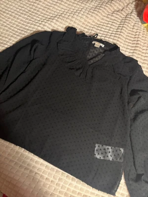 Genomskinlig blus gina tricot - En fin blus ifrån Gina tricot. Mycket fint med ett svart linne under. Den har ett V linje och massa mönster. Den är genomskinlig. 