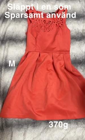 Korallröd klänning med utskuren detalj - Superfin korallröd klänning med utskurna detaljer upptill och veckad kjol. Ärmlös modell med rund halsringning och dragkedja i ryggen. Perfekt för dig som vill sticka ut lite extra med en färgstark look.🌸Sparsamt använd men har släppt i en söm. Storlek m