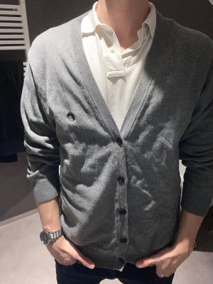 Grå cardigan med knappar från chaps by Ralph lauren - Säljer denna as snygga cardiganen från chaps by Ralph lauren. Den är väldigt skön och har jätte najs passform✌️modellen i bilden är 183, 74 och tröjan är i storlek L. 