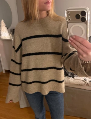 Beige stickad randig tröja - En beige stickad tröja med svarta ränder. Köptes för tre år sedan på Gina Tricot i storlek XS. Den är knappt anvönd och därför i mycket bra skick. Hör gärna av dig vid frågor❤️