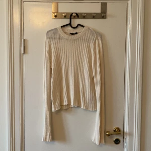 Ribbad beige stickad tröja Gina Tricot - Ribbstickad beige tröja från Gina Tricot i storlek L. Tröjan har lång ärm, rund halsringning och är tillverkad i ett stickat material.