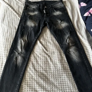 Svarta Dsquared2 ICON jeans Ibrahimovic - Säljer ett par svarta Dsquared2 ICON jeans från Ibrahimovic-kollektionen. Jeansen har slitna detaljer, skinny fit och coola blekta partier. Klassisk femficksmodell med Dsquared2-logga vid gylfen och stor ICON-lapp bak. Nypris:4700 