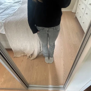 Grå bootcut jeans med låg midja - Snygga grå jeans med bootcut passform och låg midja från Gina Tricot Young. Den är väldigt enkel att styla med en svart eller vit tröja! 💞💞 Passar perfekt att ha till en mysig höstoutfit 🍁🍂 Storlek 36 runt midjan och 146 på Gina Young. Den har ett litet slitage på framsidan och en pytte liten fläck på baksidan som knappast syns!💞💞 
