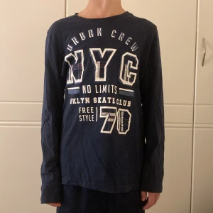 Mörkblå långärmad tröja NYC Peppets - Snygg mörkblå långärmad tröja från Pepperts med stort NYC-tryck och textdetaljer framtill. Säljer då den inte kommer till användning.