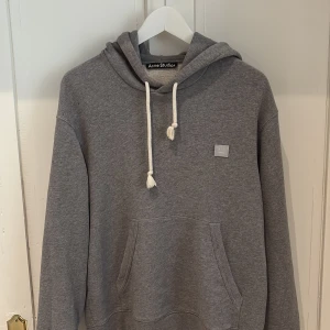 Grå hoodie från Acne Studios - Säljer en stilren grå hoodie från Acne Studios med vit snörning i huvan och klassisk logopatch på bröstet. Nypris 2999kr men ligger ute för 2125kr pris kan diskuteras 