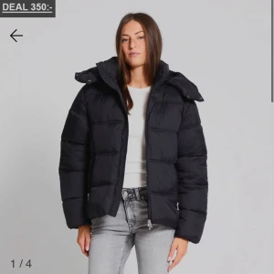 Svart pufferjacka med huva - Säljer en slutsåld svart pufferjacka med huva och dragkedja framtill från lager 157!  Jackan har en boxig passform och breda axlar som ger en cool look. Perfekt för kalla dagar när du vill hålla värmen och ändå se snygg ut. Inget slitage på den säljer då jqh vill köpa ny endast. Har tyvärr ingen bild med den på men den ser ut som på bilden!💕