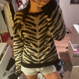 Zebramönstrad stickad tröja - Säljer en mjuk stickad tröja med zebramönster i svart och beige. Mjuk och skön att ha på sig under kyligare dagar🦓🍁❄️ Hör av dig vid frågor🥰