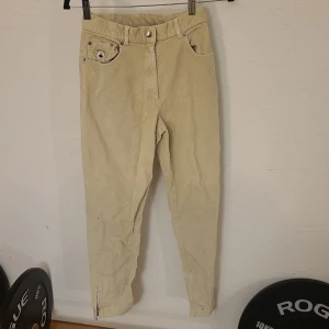 Beiga manchesterbyxor från Ice Sport - Beiga manchesterbyxor från Ice Sport med broderad björn på fickan och dragkedja vid benslut. Byxorna har klassisk femficksdesign och är tillverkade i mjuk manchester. Perfekta för dig som gillar retrostil och vill sticka ut med coola detaljer. Den är lite dammig för att jag har inte använt den på ett tag