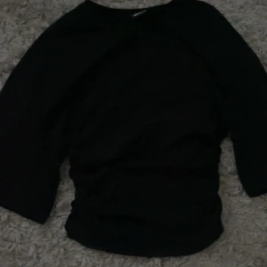 Svart croppad topp från Gina Tricot - Säljer en svart croppad topp från Gina Tricot i storlek XXS. T-shirten har korta ärmar och en tight passform som sitter snyggt på kroppen. Perfekt till jeans eller kjol för en clean och enkel look.