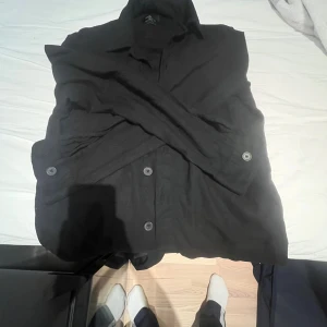 Svart overshirt från Springfield XS - Svart overshirt från Springfield i regular fit. Skjortjackan har klassisk krage, knäppning framtill med svarta knappar och långa ärmar. Perfekt att slänga över en hoodie eller t-shirt för en clean look.