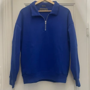 Blå half zip från Abercrombie - Säljer en blå tröja från Abercrombie & Fitch med halv dragkedja och hög krage. Tröjan är långärmad och tillverkad i en mjuk bomullsblandning, perfekt för en chill och avslappnad stil.
