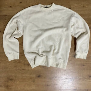 Vit sweatshirt med rund hals - En stilren vit sweatshirt med rund hals och ribbade muddar vid ärmslut och nederkant. Tröjan har en klassisk passform och är perfekt för dig som gillar en clean och enkel look. Långärmad och i mjukt material som känns skönt mot huden.