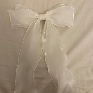 Vit glansig rosett klämma för håret - Superfin stor vit rosett i glansigt tyg med hårspänne på baksidan. Mycket bra skick har använt endast en  gång.