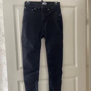 Svarta skinny jeans med hög midja - Snygga svarta skinny jeans med hög midja och klassisk femficksdesign. Jeansen har smal passform hela vägen ner och är tillverkade i stretchigt jeansmaterial för en bekväm känsla. Perfekta att matcha med en oversized hoodie eller en crop top.