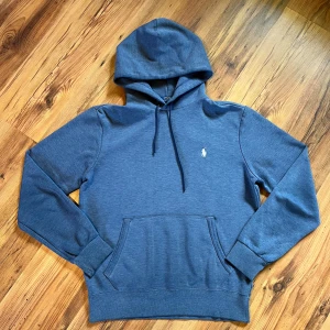 Blå hoodie från Polo Ralph Lauren - Snygg blå hoodie från Polo Ralph Lauren         -9.5/10 skick, bara tappat färgen lite                - Längd -63 cm / bredd - 49 cm / ärm - 60 cm - Size S/170                                                                - Material: bomull & polyester 🧶                          Hör av er, gärna 